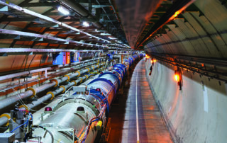 Il Large Hadron Collider (LHC), il più grande e potente acceleratore di particelle al mondo, situato al CERN vicino a Ginevra. LHC fa collidere protoni (e nuclei pesanti) circolanti in due anelli di 27 km a energie fino a 14 TeV, ricreando condizioni simili a quelle dell’universo primordiale, per studiare le particelle fondamentali e le leggi della fisica. Grazie a questa straordinaria macchina si è scoperto il bosone di Higgs.